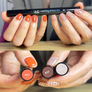 テラコッタのワンカラーとブラウンチェックのアシンメトリーネイルでポージングしている手元のアップ