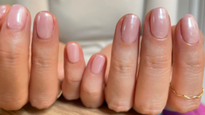 ピンクのワンカラーネイルをした指先のアップ