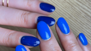 2色のブルーのワンカラーネイルをしている指先のアップ