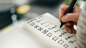 チェックリストにマジックペンでチェックを入れていく手元のアップ。