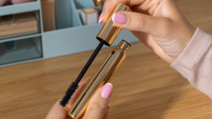 まつ毛美容液の容器を持っている女性の手元のアップ