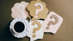 テーブルにクエスチョンマークが並んでいてコーヒーカップが添えてある