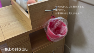 一番上のデスクの引き出しにフックを付けて小さなピンクのボミ箱をつるしている様子