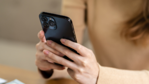 女性がスマホを両手で持ち、操作している様子